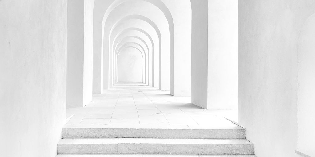 White arches and stone steps leading forward into soft light