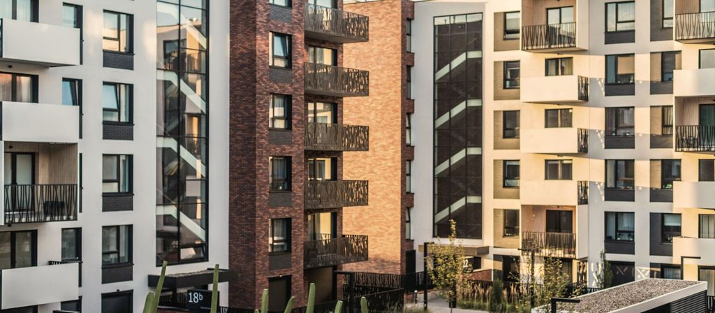 Modern apartment buildings with balconies around a planted courtyard