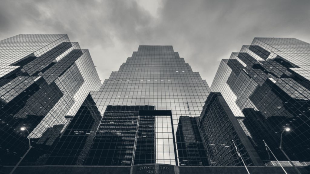 Glass towers rising into a grey sky