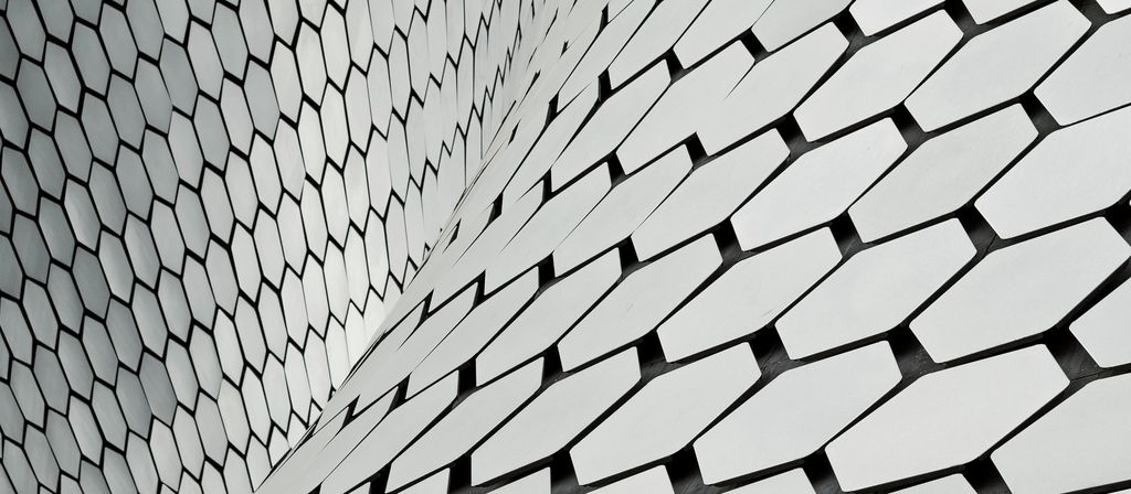 A sweeping white wall of hexagonal tiles curving overhead